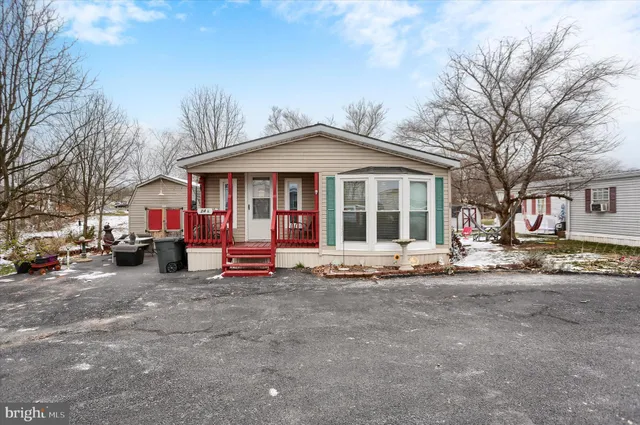 a front view of a house with a garden and trees