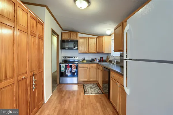a kitchen with stainless steel appliances granite countertop a refrigerator and a stove top oven