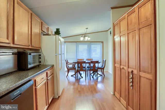 a kitchen with stainless steel appliances granite countertop furniture wooden floor and a window