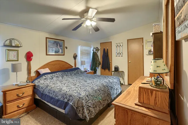a bedroom with a bed and dresser with mirror