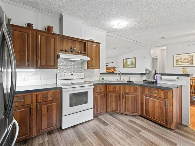 a kitchen with stainless steel appliances granite countertop a stove a sink and a refrigerator