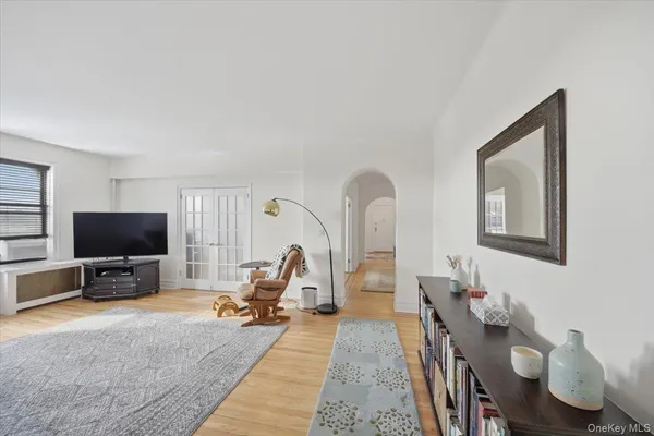 a living room with furniture a flat screen tv and a large window