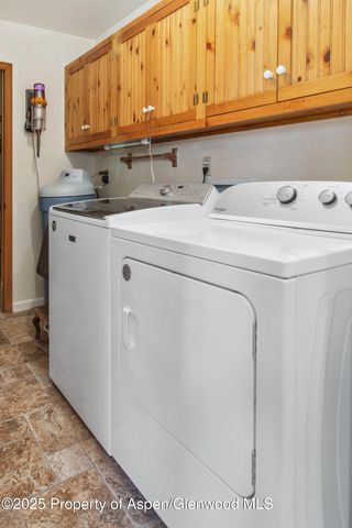 a view of a house with a big yard and large trees