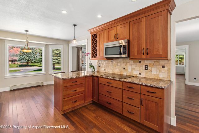 a kitchen with stainless steel appliances granite countertop a stove a sink and a microwave