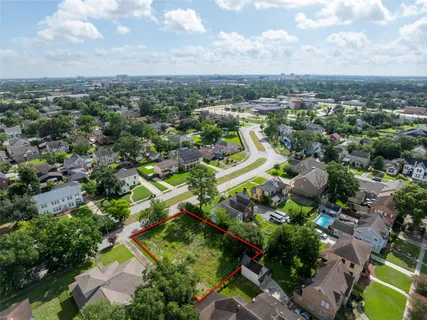 an aerial view of residential houses with outdoor space and trees