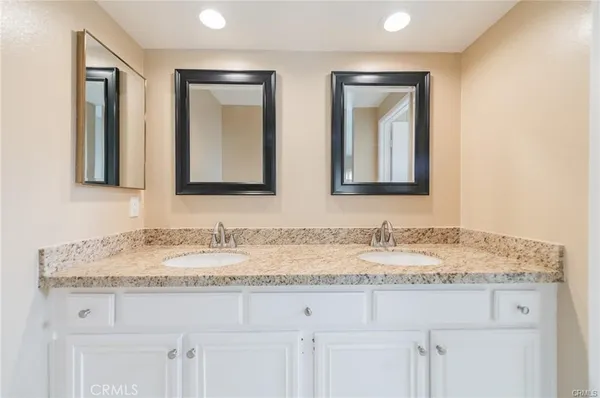 a bathroom with double sink and a mirror
