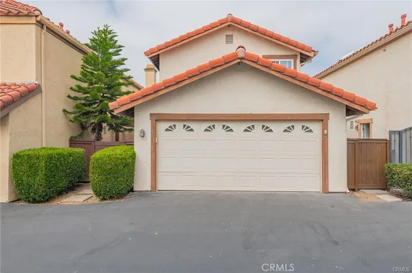 a view of a house with a small yard and garage