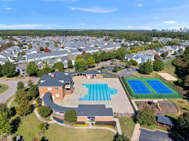 an aerial view of residential houses with outdoor space and ocean view