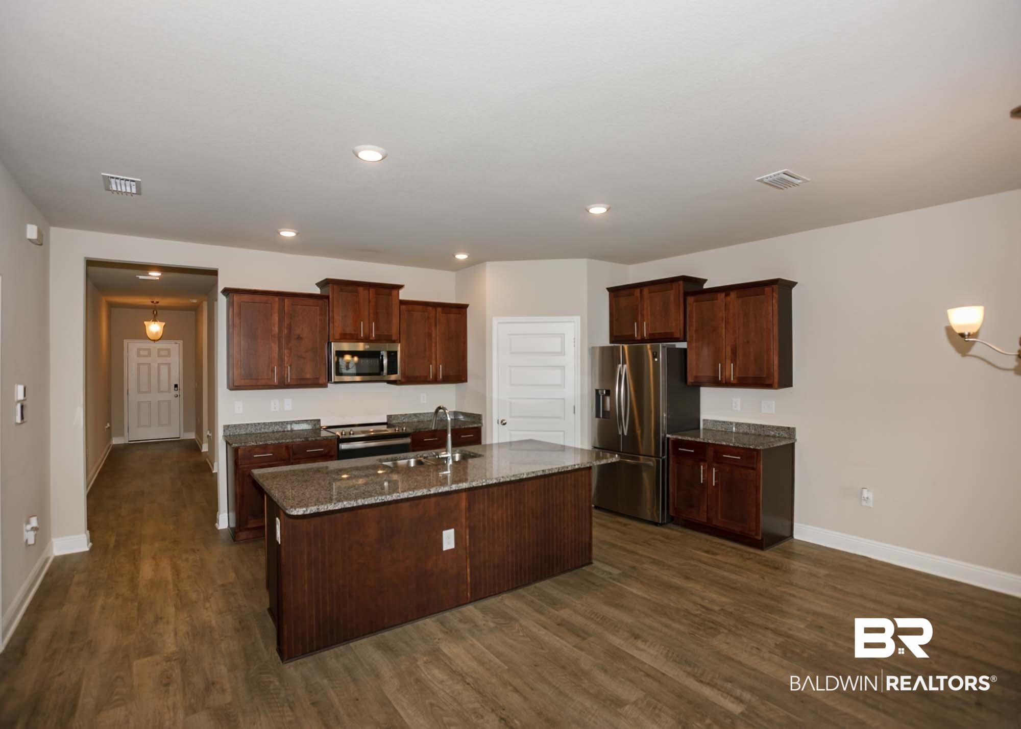 1436 Kairos Loop Foley, AL 36535 - Photo 10 of 52 Kitchen with appliances with stainless steel finishes, dark wood-style flooring, a center island with sink, dark stone countertops, and recessed lighting