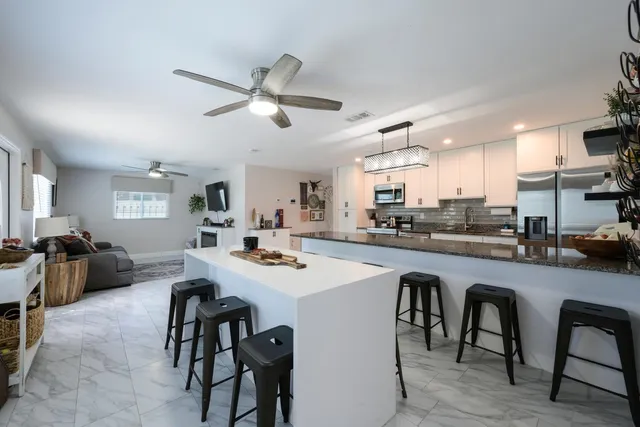 a kitchen with a dining table chairs and white cabinets