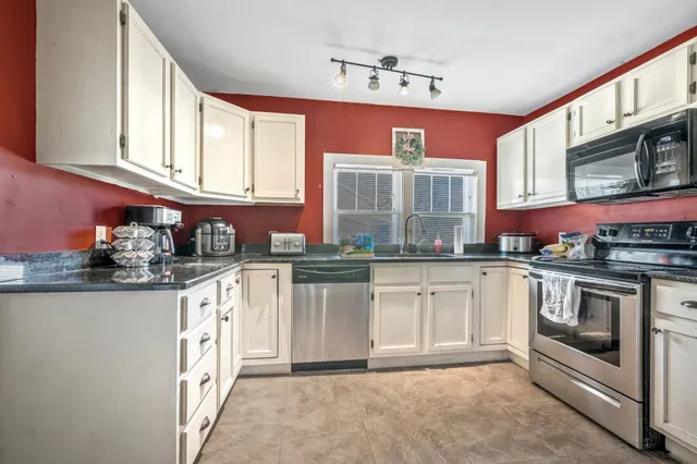 a kitchen with stainless steel appliances granite countertop a stove and cabinets
