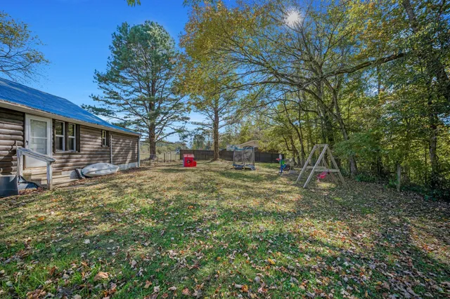a view of a yard with a house and a tree