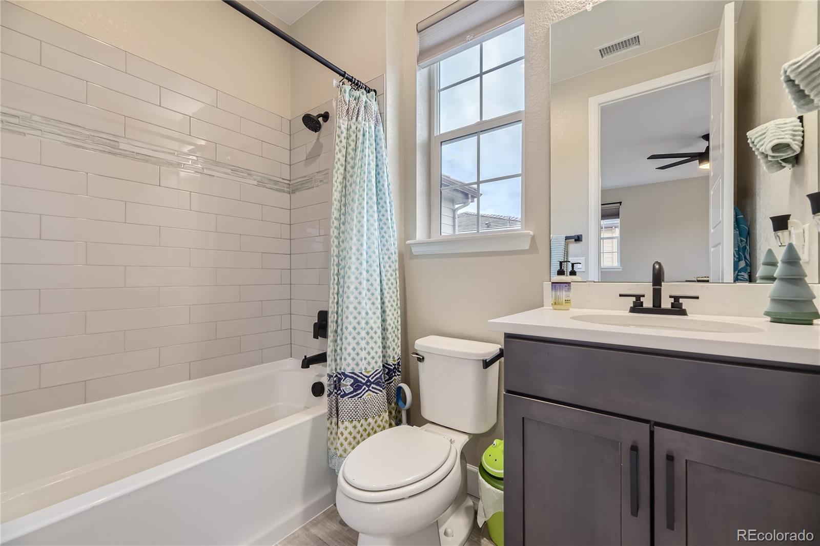 11330 Yellow Tip Point Parker, CO 80134 - Photo 36 of 50 a bathroom with a sink a toilet a mirror a bathtub and shower