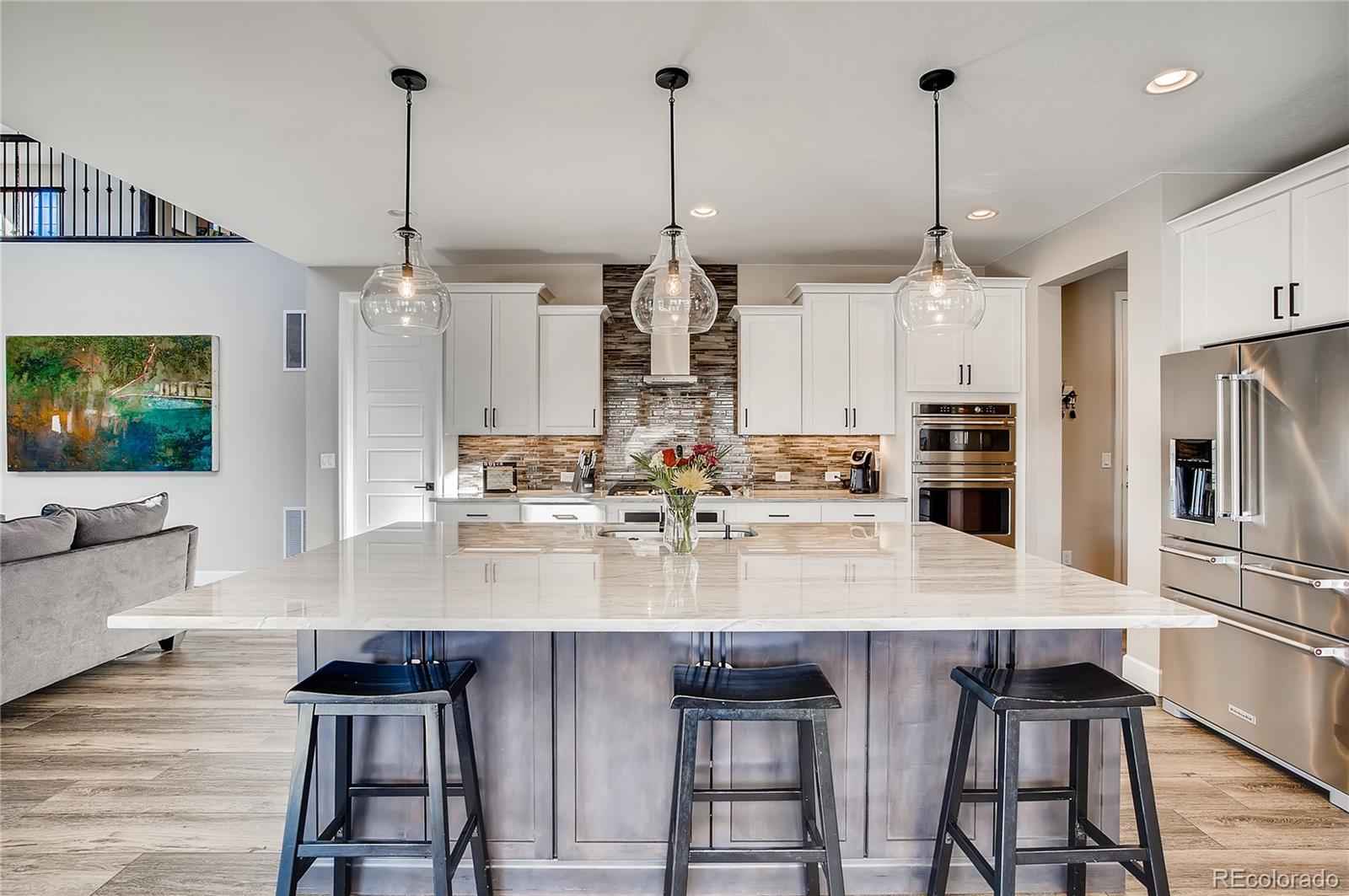 11330 Yellow Tip Point Parker, CO 80134 - Photo 10 of 50 a kitchen with kitchen island granite countertop a table chairs stainless steel appliances and cabinets