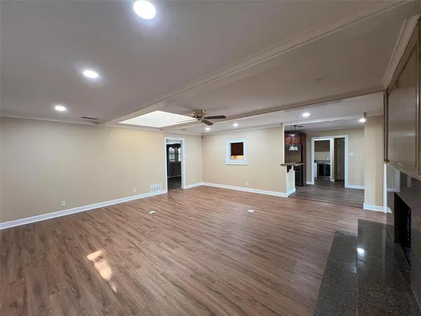 an empty room with wooden floor and a window