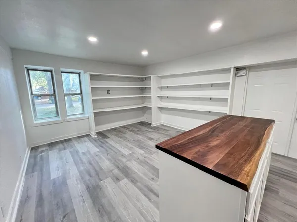 a large kitchen with a wooden floor and outdoor space