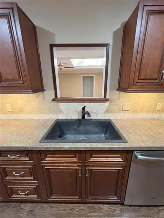 a close view of a sink a mirror and cabinets
