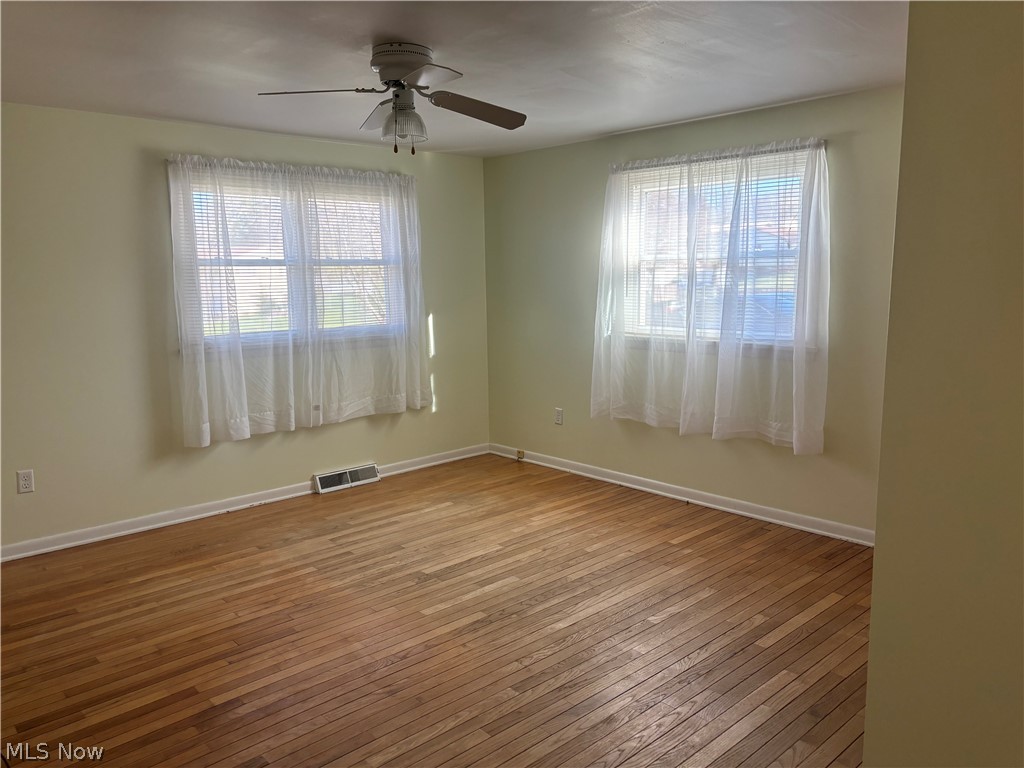 64197 Morrison Road Cambridge, OH 43725 - Photo 30 of 41 Empty room with hardwood / wood-style floors, ceiling fan, and a wealth of natural light