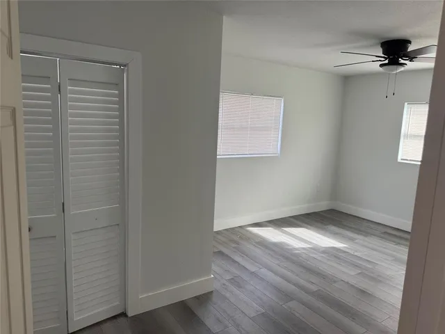 a view of an empty room with wooden floor