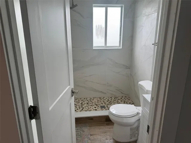 a bathroom with a toilet and a shower