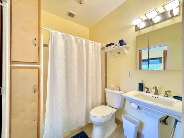 a bathroom with a granite countertop sink toilet and shower