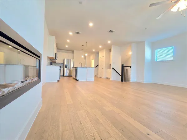 a view of a livingroom with a piano and wooden floor