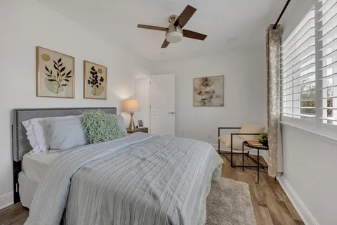 a bedroom with a bed and a table in it with window