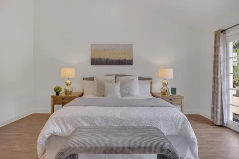 a bedroom with a bed and a painting on the wall