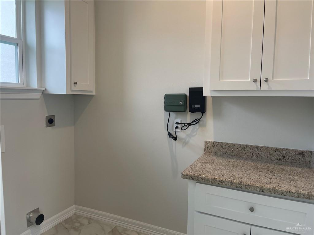 5515 North Crown Point Pharr, TX 78577 - Photo 2 of 15 Laundry room featuring cabinet space, hookup for an electric dryer, and light marble finish floors