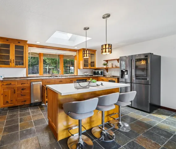 a kitchen with a sink a counter top space appliances and cabinets