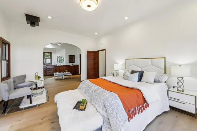 a spacious bedroom with a bed a couch and a view of living room