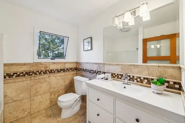 a bathroom with a toilet a sink a mirror and a shower