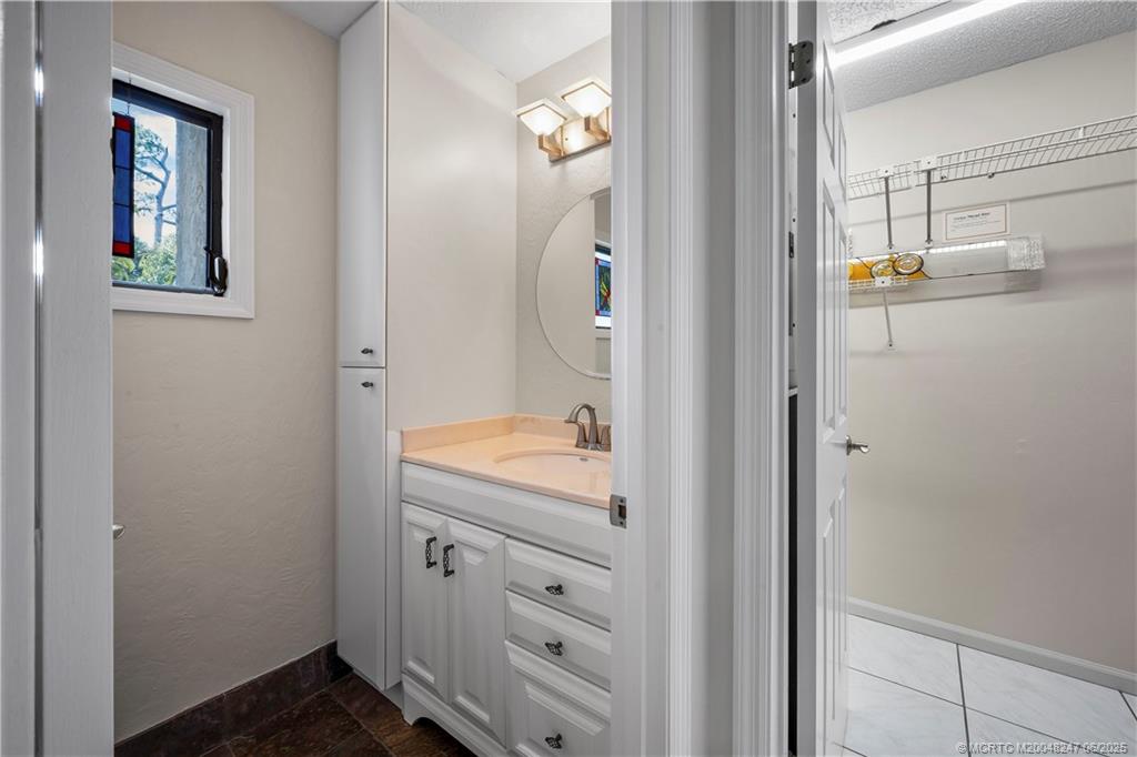 4761 Southeast Binnacle Way, Unit 108 Stuart, FL 34997 - Photo 12 of 43 a bathroom with a granite countertop sink and a mirror