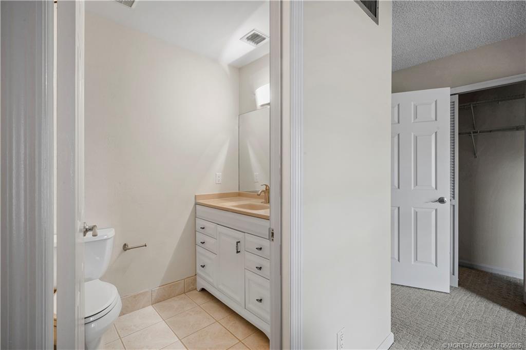 4761 Southeast Binnacle Way, Unit 108 Stuart, FL 34997 - Photo 25 of 43 a bathroom with a granite countertop toilet and a shower