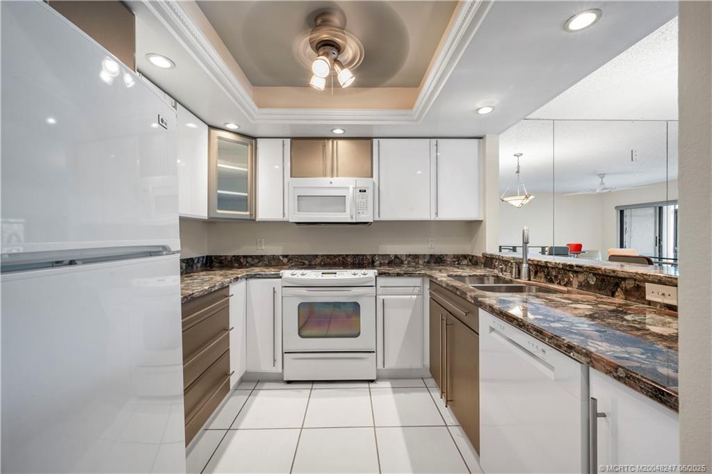 4761 Southeast Binnacle Way, Unit 108 Stuart, FL 34997 - Photo 8 of 43 a kitchen with a stove sink and cabinets