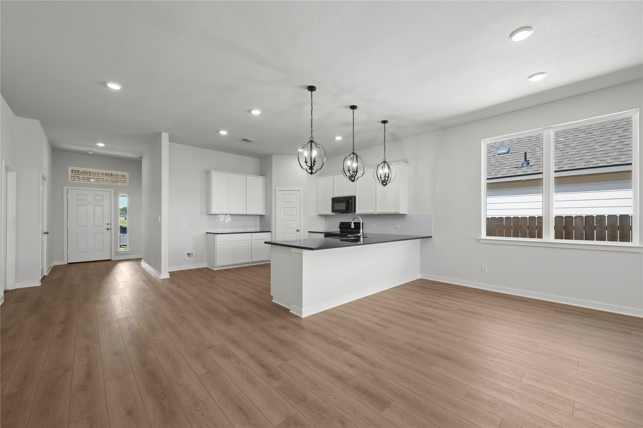 220 Gus Loop Georgetown, TX 78626 - Photo 13 of 18 An open-concept living area features a contemporary kitchen island and wide-plank flooring throughout.