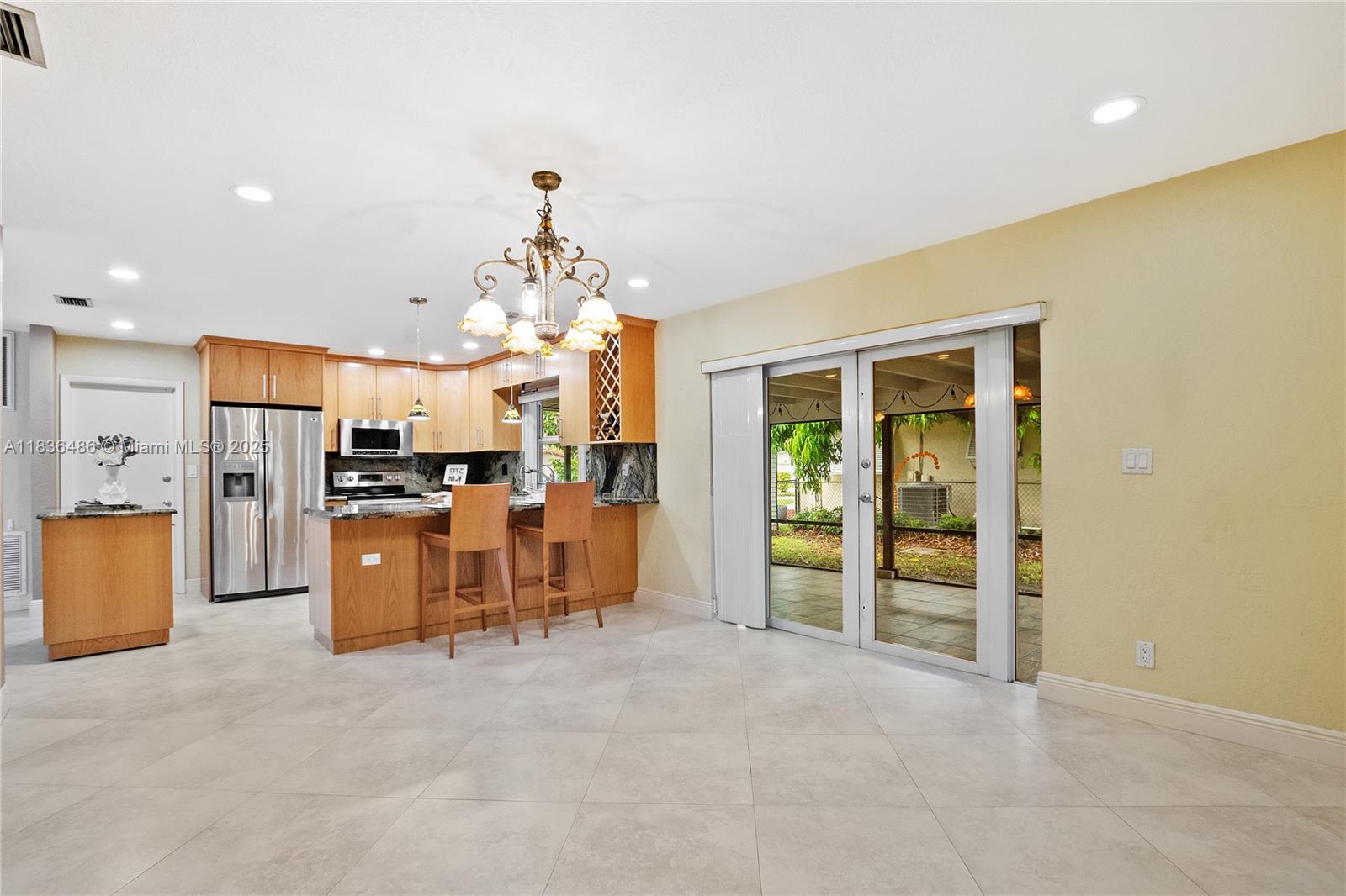 180 Southwest 125th Avenue Plantation, FL 33325 - Photo 12 of 29 a view of a kitchen with refrigerator and a living room