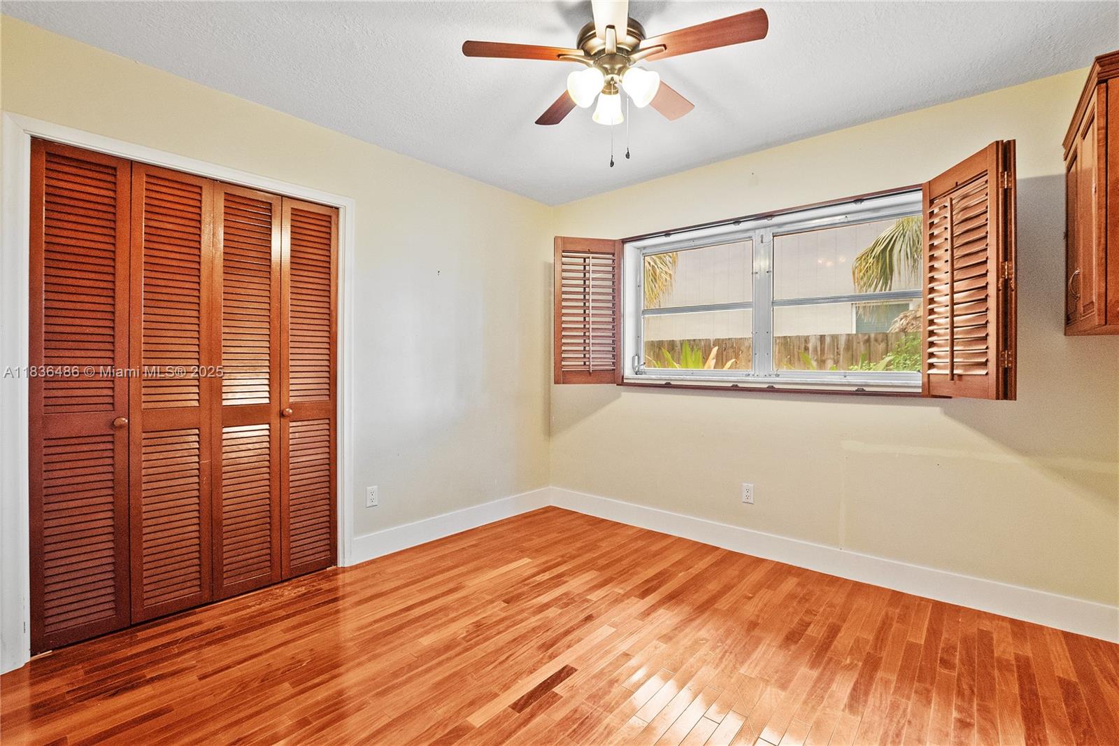 180 Southwest 125th Avenue Plantation, FL 33325 - Photo 22 of 29 an empty room with wooden floor fan and windows