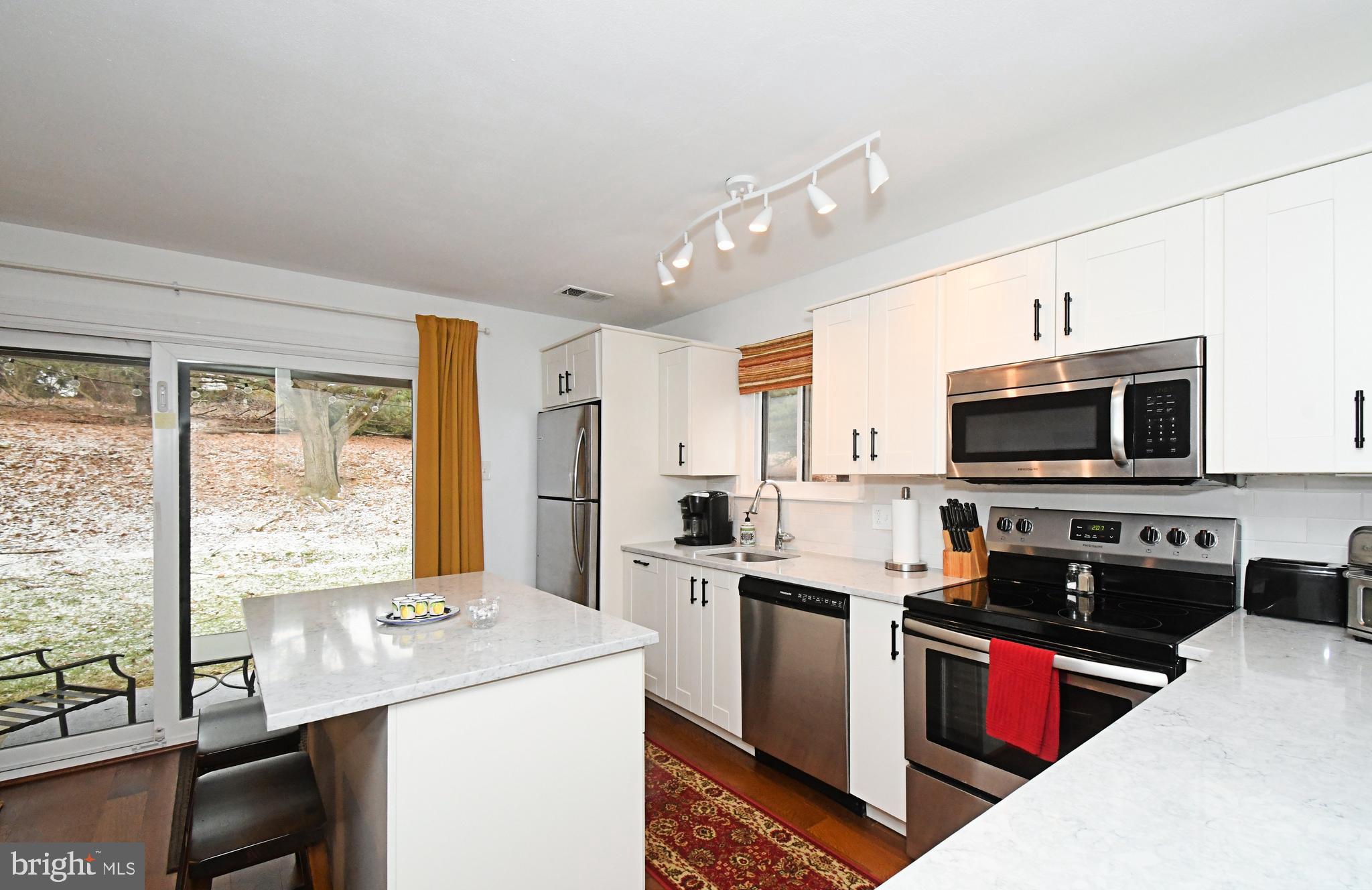 28 Flintlock Lane Chesterbrook, PA 19087 - Photo 33 of 69 a kitchen with stainless steel appliances granite countertop a stove top oven a sink dishwasher and a refrigerator with wooden floor
