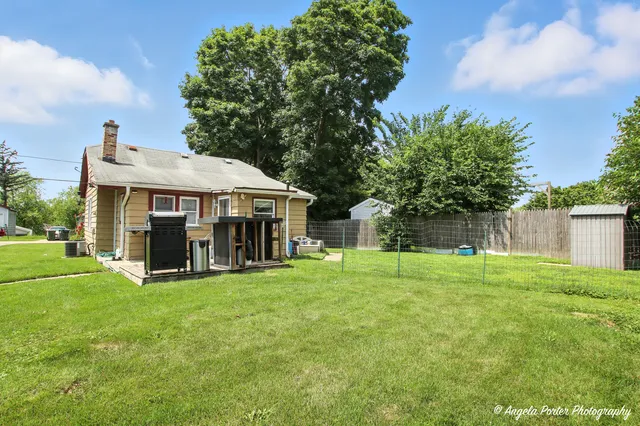a view of a house with a yard and sitting area