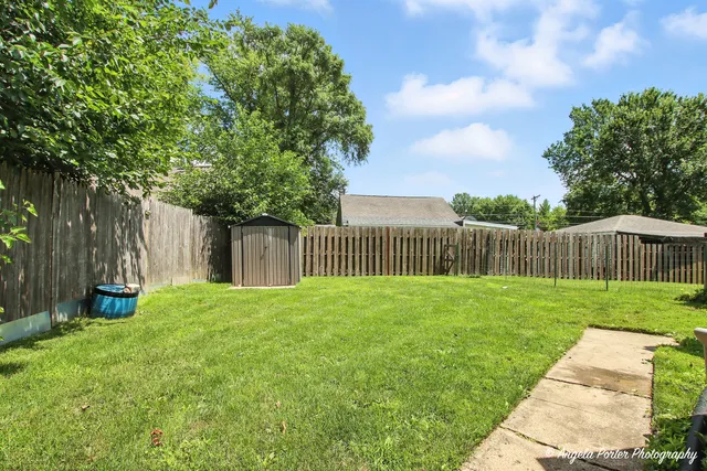 a view of a yard with wooden fence