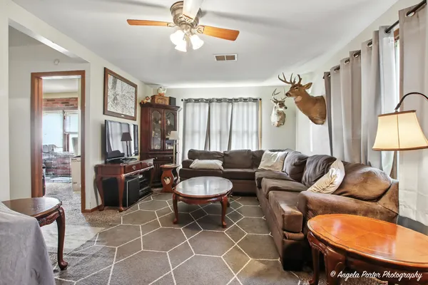 a living room with furniture a ceiling fan and a window