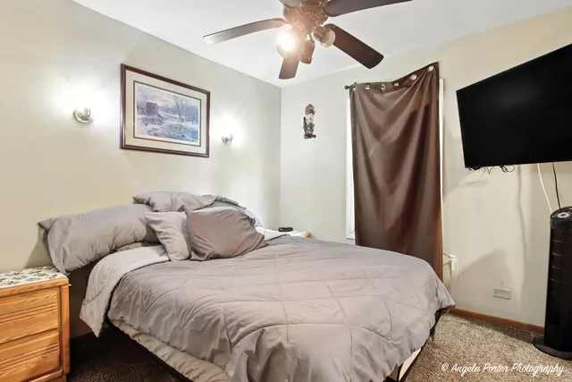 a bedroom with bed and a flat screen tv