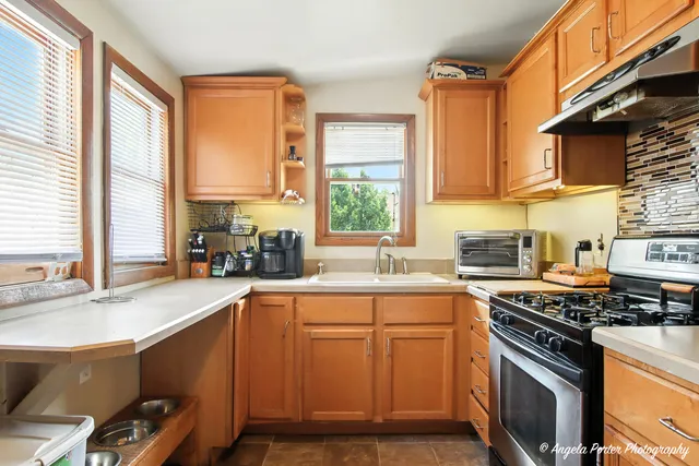 a kitchen with a sink stove top oven and cabinets