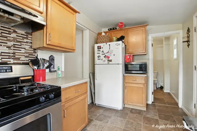 a kitchen with stainless steel appliances granite countertop a refrigerator and a stove