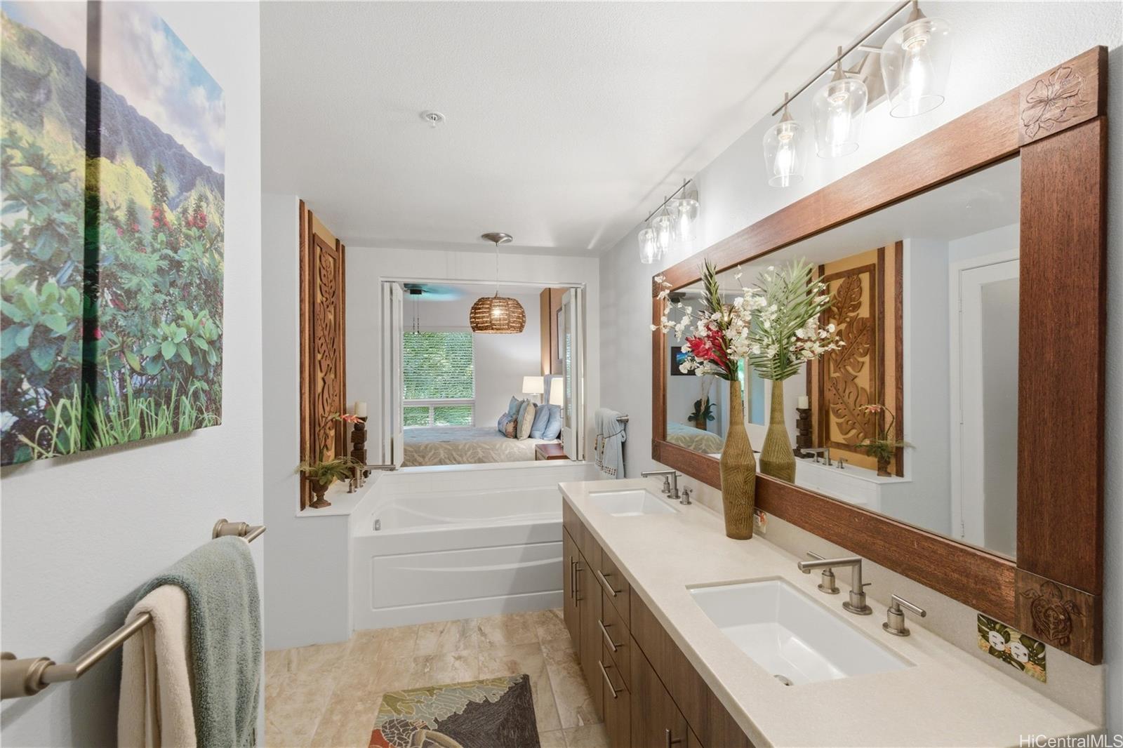 437 Kailua Road, Unit 6108 Kailua, HI 96734 - Photo 15 of 25 Spa inspired bathroom featuring a large soaking tub with an optional view into the primary bedroom and a mirror framed in mahogany.