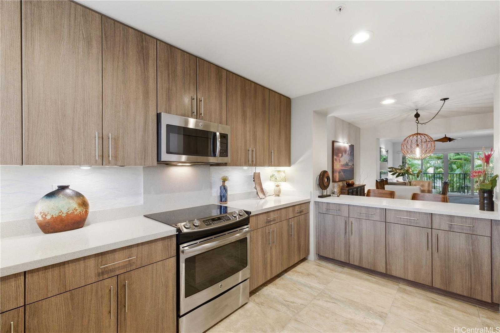 437 Kailua Road, Unit 6108 Kailua, HI 96734 - Photo 6 of 25 Kitchen offers abundant storage including a pantry, while under cabinet lighting highlights the countertops and backsplash, adding both function and style.