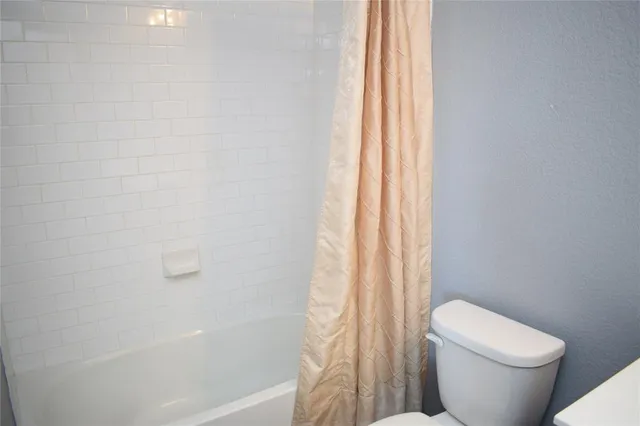 a white toilet sitting next to a bath tub