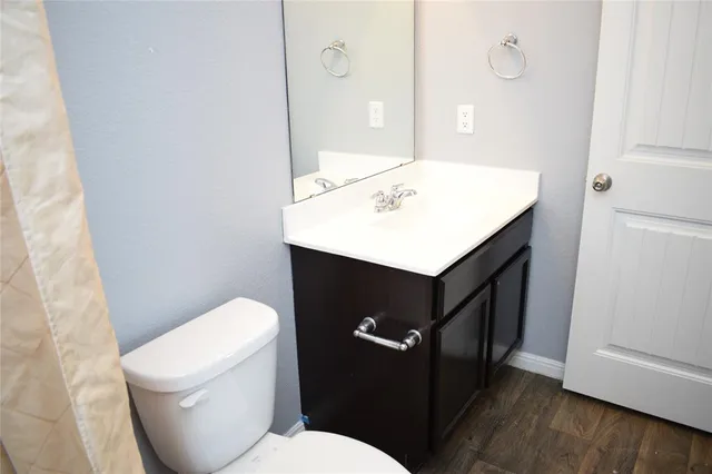 a bathroom with a sink a toilet a mirror and vanity