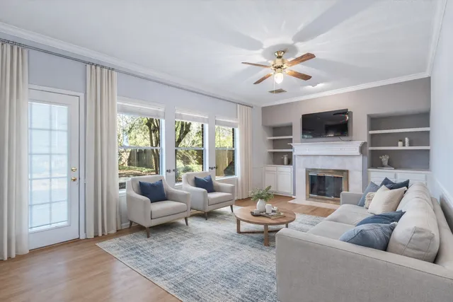 a living room with furniture a fireplace and a flat screen tv